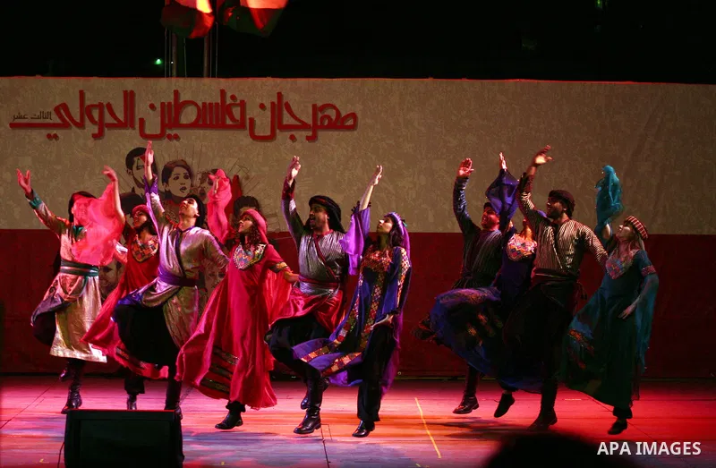 Dancers of the El-Funoun Palestinian Popular Dance Troupe perform on the third day of the 13th Palestine International Festival in the West Bank city of Ramallah on July 6, 2011. The festival, which features music and da...