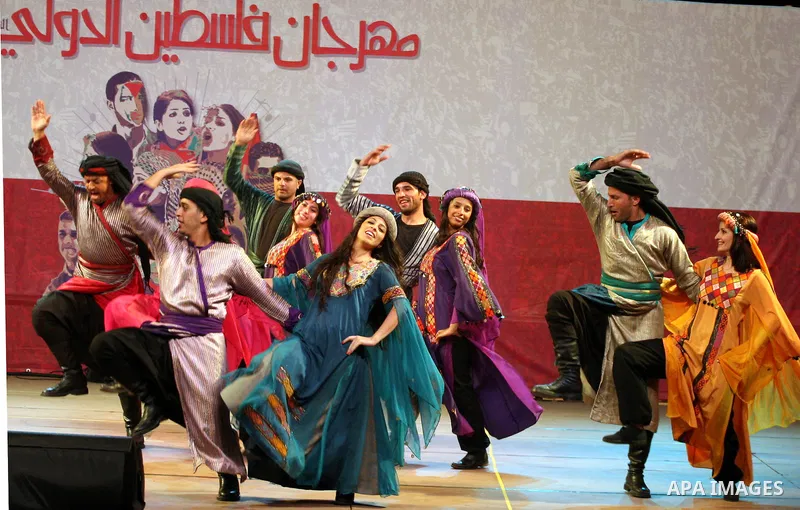 Dancers of the El-Funoun Palestinian Popular Dance Troupe perform on the third day of the 13th Palestine International Festival in the West Bank city of Ramallah on July 6, 2011. The festival, which features music and da...