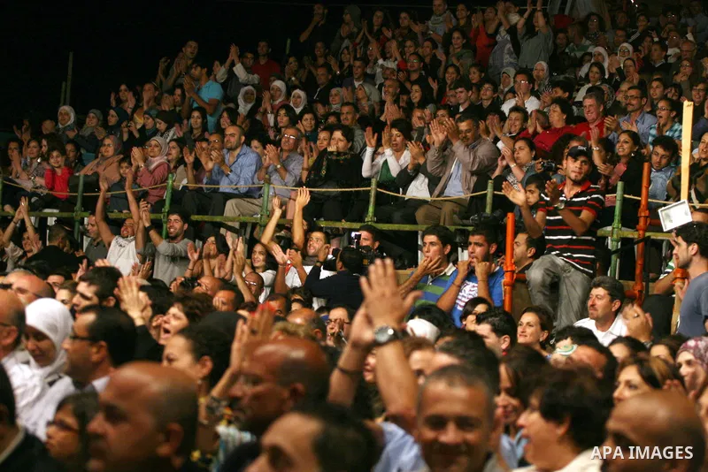 Palestinians attend the dancers of the El-Funoun Palestinian Popular Dance Troupe perform on the third day of the 13th Palestine International Festival in the West Bank city of Ramallah on July 6, 2011. The festival, whi...
