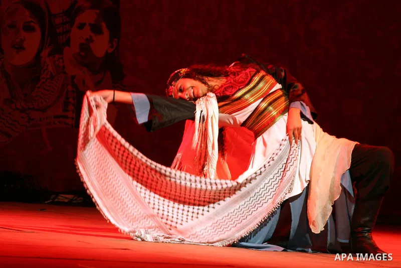 Dancers of the El-Funoun Palestinian Popular Dance Troupe perform on the third day of the 13th Palestine International Festival in the West Bank city of Ramallah on July 6, 2011. The festival, which features music and da...