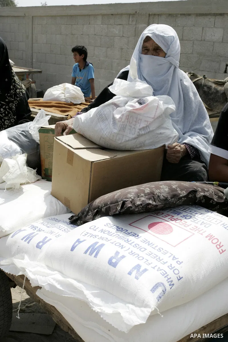 A Palestinian woman receives humanitarian aid at the United Nations aid distribution centre in the refugee camp of Rafah in the southern Gaza Strip on July 7, 2011. United Nations Relief and Works Agency (UNRWA) decide t...