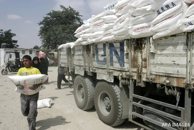 Palestinians receive humanitarian aid at the United Nations aid distribution centre in the refugee camp of Rafah in the southern Gaza Strip on July 7, 2011. United Nations Relief and Works Agency (UNRWA) decide to change...