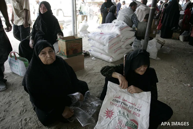 Palestinians receive humanitarian aid at the United Nations aid distribution centre in the refugee camp of Rafah in the southern Gaza Strip on July 7, 2011. United Nations Relief and Works Agency (UNRWA) decide to change...