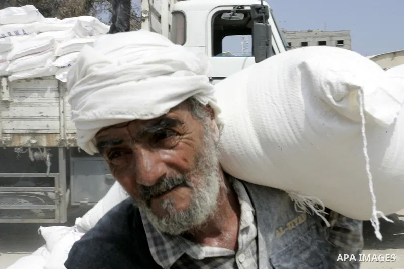 A Palestinian man receives humanitarian aid at the United Nations aid distribution centre in the refugee camp of Rafah in the southern Gaza Strip on July 7, 2011. United Nations Relief and Works Agency (UNRWA) decide to...