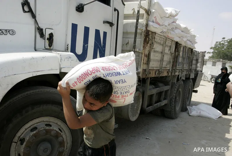 Palestinians receive humanitarian aid at the United Nations aid distribution centre in the refugee camp of Rafah in the southern Gaza Strip on July 7, 2011. United Nations Relief and Works Agency (UNRWA) decide to change...