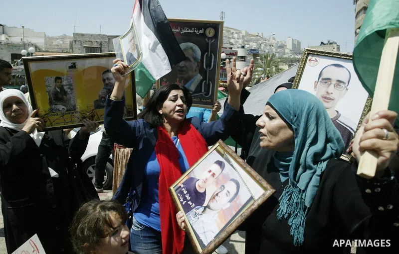Palestinian women hold pictures of their relatives, held in Israeli jails, during a protest calling for their release in the West Bank city of Nablus, Thursday, July 7, 2011. Israel currently holds about 5,600 Palestinia...