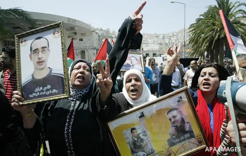 Palestinian women hold pictures of their relatives, held in Israeli jails, during a protest calling for their release in the West Bank city of Nablus, Thursday, July 7, 2011. Israel currently holds about 5,600 Palestinia...