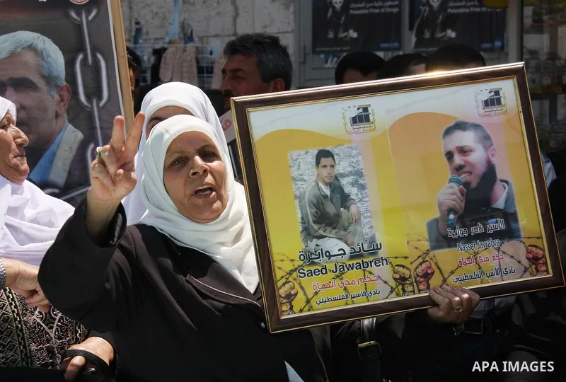 Palestinian women hold pictures of their relatives, held in Israeli jails, during a protest calling for their release in the West Bank city of Nablus, Thursday, July 7, 2011. Israel currently holds about 5,600 Palestinia...