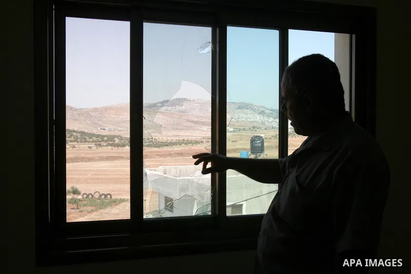 Palestinian stands by the broken window at the family home after Israeli forces raided and arrested the youth Khaldoun Hassan Issa, 25 years, in the West Bank village of Salem , Friday, July 8, 2011 . Photo by Wagdi Esht...