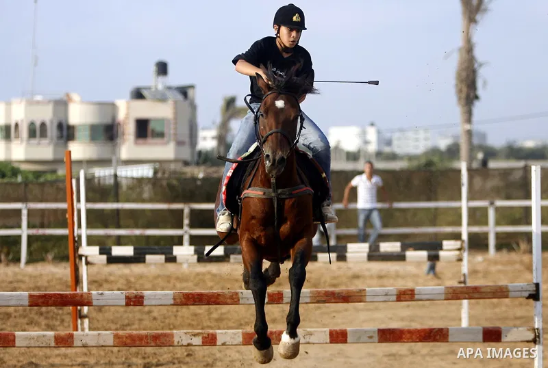 A Palestinian rides a horse during the "Jump Championship" race in Gaza City July 8, 2011. Photo by Ali Jadallah