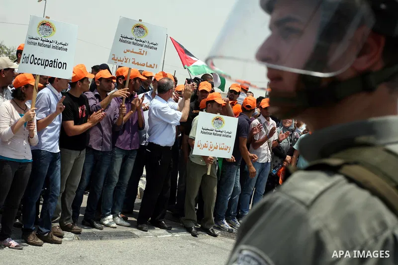 Locally-based Palestinian demonstrators take part in a protest at the Qalandia checkpoint between the West Bank city of Ramallah and Jerusalem, Saturday, July 9, 2011. Israel's interior ministry says it has questioned ov...