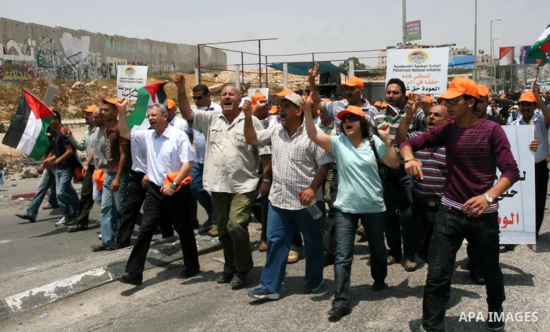 Locally-based Palestinian demonstrators take part in a protest at the Qalandia checkpoint between the West Bank city of Ramallah and Jerusalem, Saturday, July 9, 2011. Israel's interior ministry says it has questioned ov...