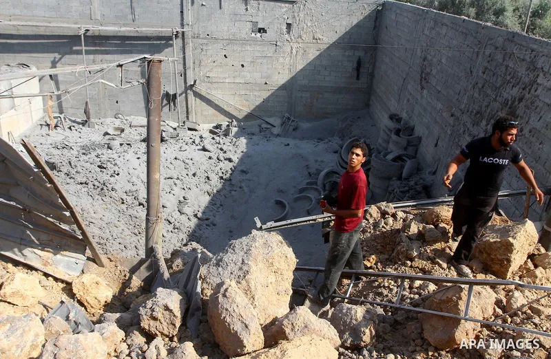 Palestinians inspect amid the ruins of a building bombed by Israeli aircraft in the east of Gaza City on July 10, 2011. Photo by Ashraf Amra