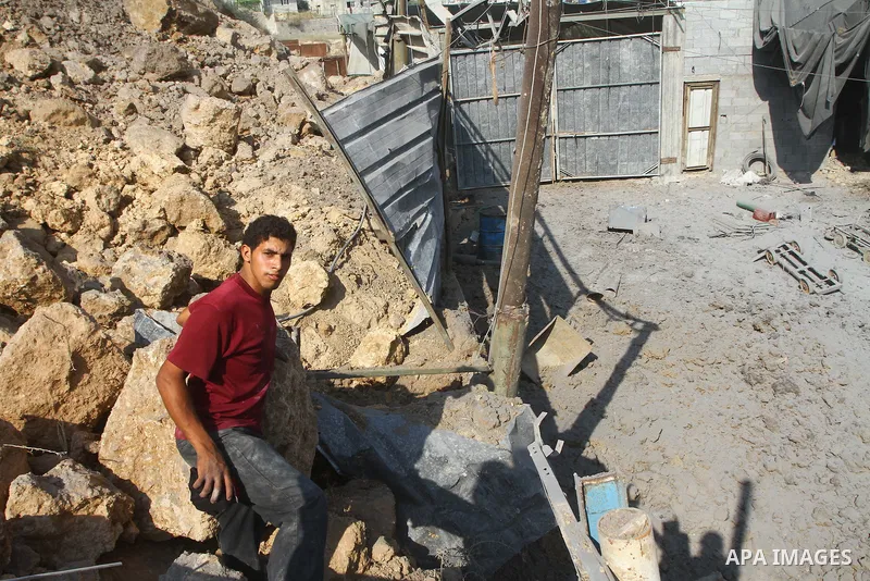 A Palestinian man inspects amid the ruins of a building bombed by Israeli aircraft in the east of Gaza City on July 10, 2011. Photo by Ashraf Amra
