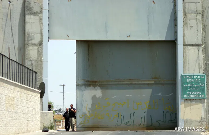 Israeli soldiers stand guard as Palestinians and foreigners protest in front of a section of Israel's controversial separation barrier at the main entrance of the West Bank city of Bethlehem on July 10, 2011, marking the...