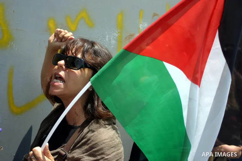 Palestinians and foreigners protest in front of a section of Israel's controversial separation barrier at the main entrance of the West Bank city of Bethlehem on July 10, 2011, marking the seventh anniversary of a ruling...
