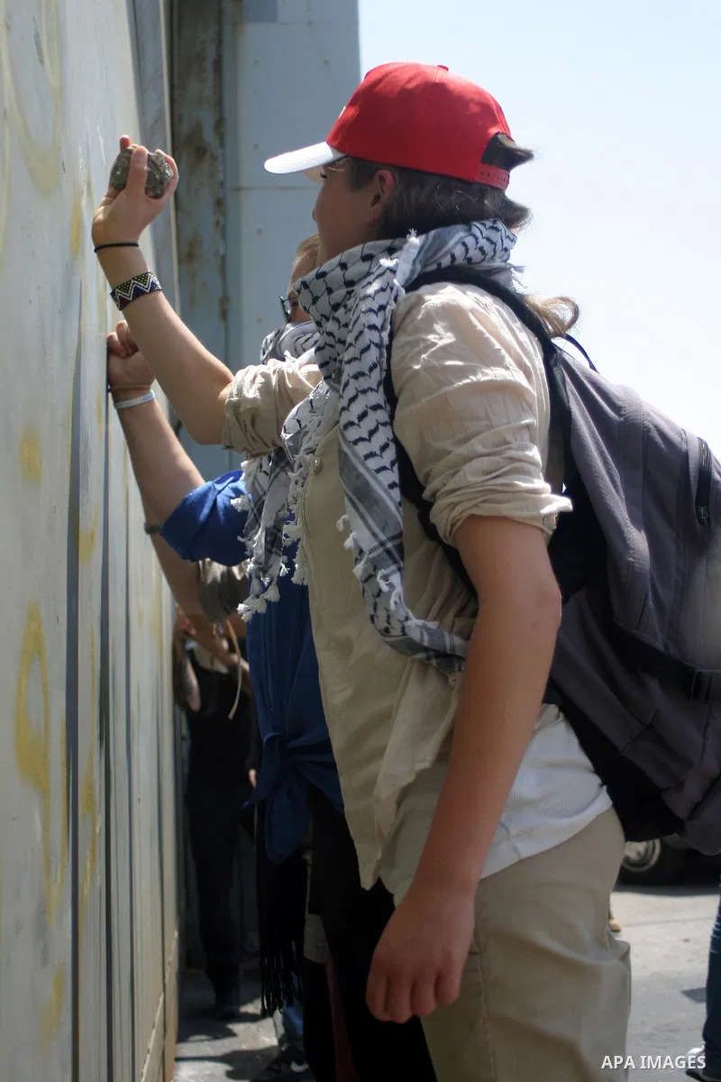 Palestinians and foreigners protest in front of a section of Israel's controversial separation barrier at the main entrance of the West Bank city of Bethlehem on July 10, 2011, marking the seventh anniversary of a ruling...