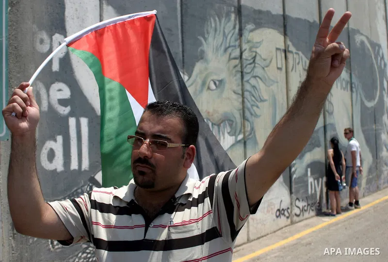 Palestinians and foreigners protest in front of a section of Israel's controversial separation barrier at the main entrance of the West Bank city of Bethlehem on July 10, 2011, marking the seventh anniversary of a ruling...