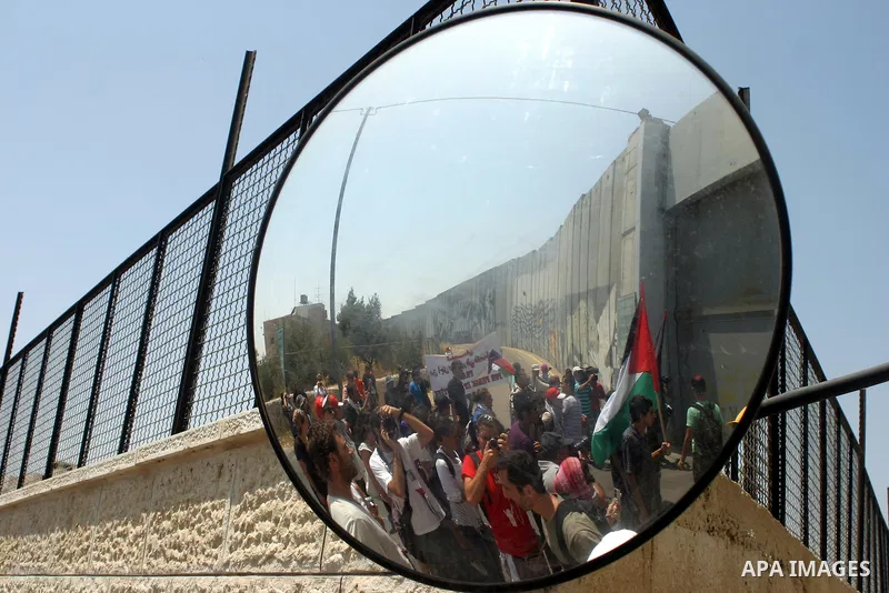 Palestinians and foreigners protest in front of a section of Israel's controversial separation barrier at the main entrance of the West Bank city of Bethlehem on July 10, 2011, marking the seventh anniversary of a ruling...