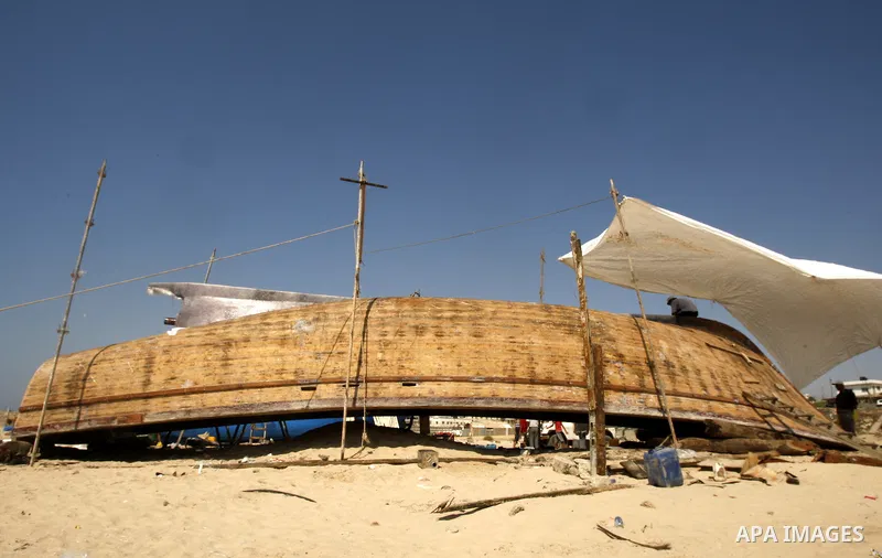 Palestinian fishermen repair their boat on Gaza city beach on July 10,2011. Photo by Mahmoud Nassar