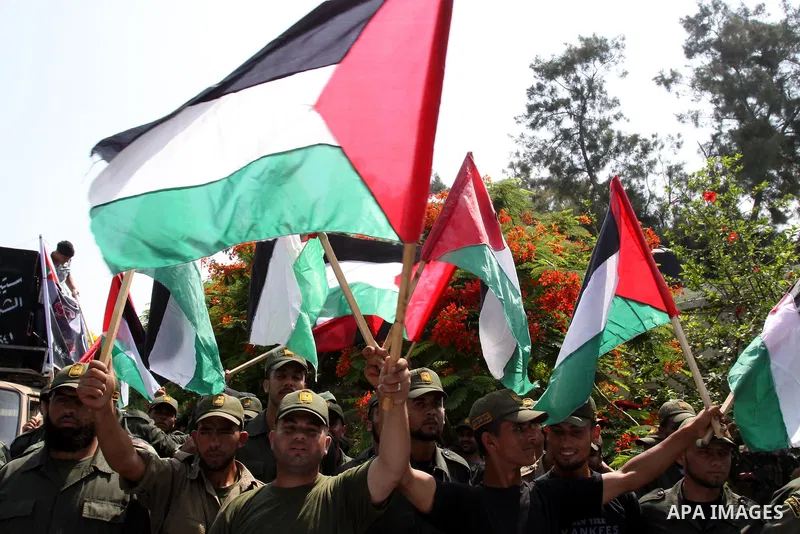 Palestinian Hamas security forces hold national flags during a protest in front of UNRWA headquarters in Gaza city on July 12, 2011 in support with Jerusalem's parliament members who have been living inside the ICRC comp...