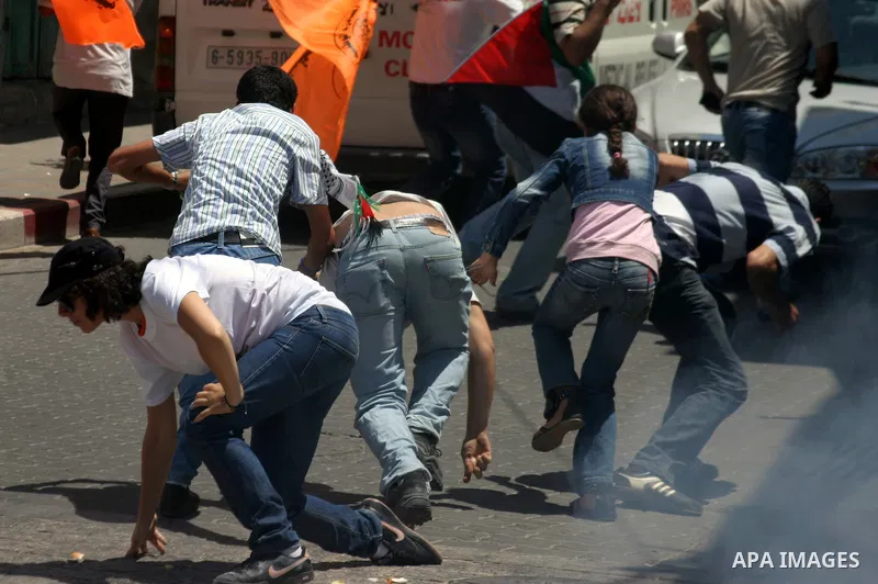 Palestinians and International activists demonstrate against the closure of Shuhada Street in Hebron, the main artery blocked by an Israeli military checkpoint in the center of the West Bank town of Hebron July 12, 2011....