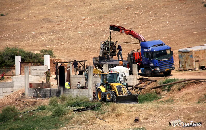 Israeli army machinery destroy a structure built around a Palestinian water well which according to farmers supply and irrigate hundreds of acres of agricultural land on July 12, 2011 in the West Bank village of al-Nassa...