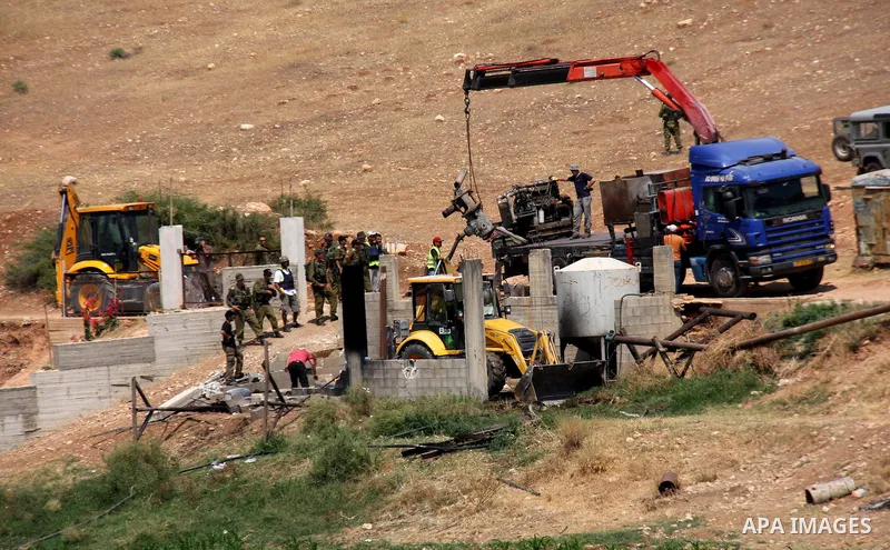 Israeli army machinery destroy a structure built around a Palestinian water well which according to farmers supply and irrigate hundreds of acres of agricultural land on July 12, 2011 in the West Bank village of al-Nassa...