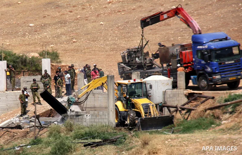 Israeli army machinery destroy a structure built around a Palestinian water well which according to farmers supply and irrigate hundreds of acres of agricultural land on July 12, 2011 in the West Bank village of al-Nassa...