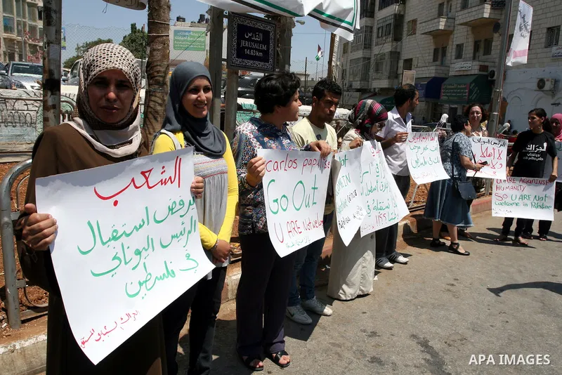 Palestinians hold signs against the visit by Greek President Karolos Papoulias to the West Bank during a protest in Ramallah on July 12, 2011. Papoulias met Palestinian Authority President Mahumud Abbas today in the West...
