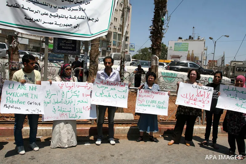 Palestinians hold signs against the visit by Greek President Karolos Papoulias to the West Bank during a protest in Ramallah on July 12, 2011. Papoulias met Palestinian Authority President Mahumud Abbas today in the West...