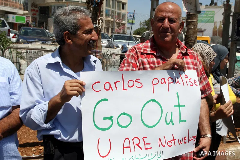 Palestinians hold signs against the visit by Greek President Karolos Papoulias to the West Bank during a protest in Ramallah on July 12, 2011. Papoulias met Palestinian Authority President Mahumud Abbas today in the West...