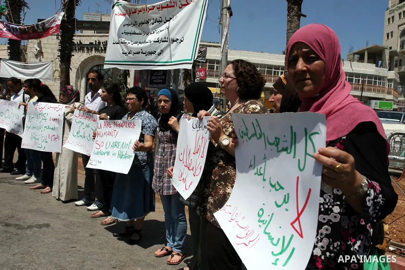 Palestinians hold signs against the visit by Greek President Karolos Papoulias to the West Bank during a protest in Ramallah on July 12, 2011. Papoulias met Palestinian Authority President Mahumud Abbas today in the West...