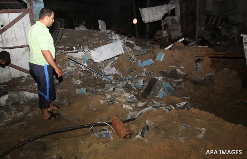 A Palestinian man inspects debris in a destroyed car wash garage after Israeli airstrike in the Al Tuffah area in the east of Gaza City, in the Gaza Strip on 12 July 2011.. Photo by Ali Jadallh