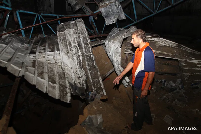 A Palestinian man inspects debris in a destroyed car wash garage after Israeli airstrike in the Al Tuffah area in the east of Gaza City, in the Gaza Strip on 12 July 2011.. Photo by Ali Jadallh