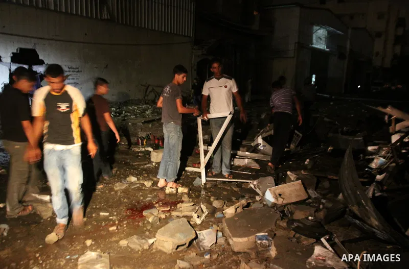 Palestinians inspect debris in a destroyed car wash garage after Israeli airstrike in the Al Tuffah area in the east of Gaza City, in the Gaza Strip on 12 July 2011. Photo by Ali Jadallh