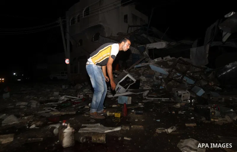 A Palestinian man inspects debris in a destroyed car wash garage after Israeli airstrike in the Al Tuffah area in the east of Gaza City, in the Gaza Strip on 12 July 2011.. Photo by Ali Jadallh