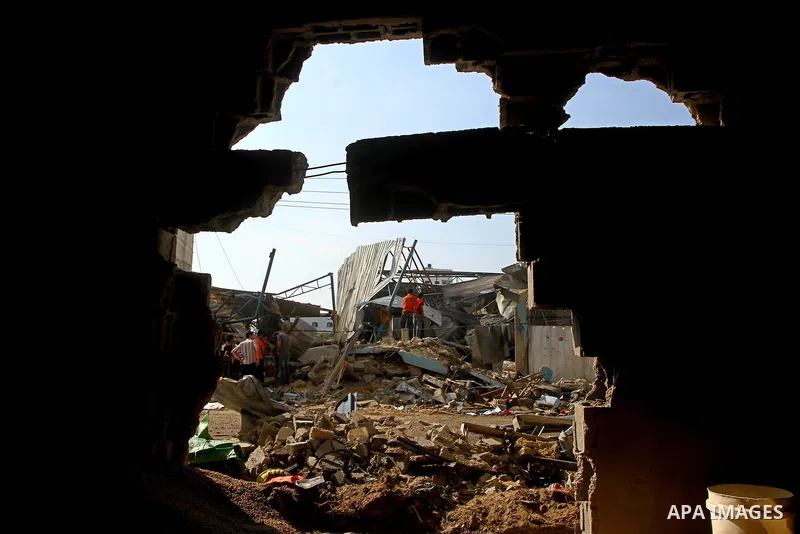 Palestinians inspect the site of an early morning Israeli airstrike in the al-Tuffah area, eastern Gaza City , which left one person wounded, on July 13, 2011, after Palestinians fired three rockets into southern Israel...