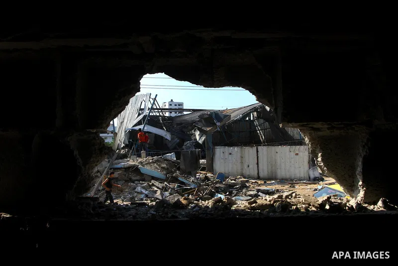 Palestinians inspect the site of an early morning Israeli airstrike in the al-Tuffah area, eastern Gaza City , which left one person wounded, on July 13, 2011, after Palestinians fired three rockets into southern Israel...