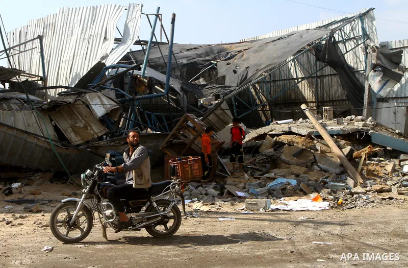 Palestinians inspect the site of an early morning Israeli airstrike in the al-Tuffah area, eastern Gaza City , which left one person wounded, on July 13, 2011, after Palestinians fired three rockets into southern Israel...