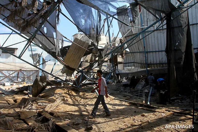 Palestinians inspect the site of an early morning Israeli airstrike in the al-Tuffah area, eastern Gaza City , which left one person wounded, on July 13, 2011, after Palestinians fired three rockets into southern Israel...