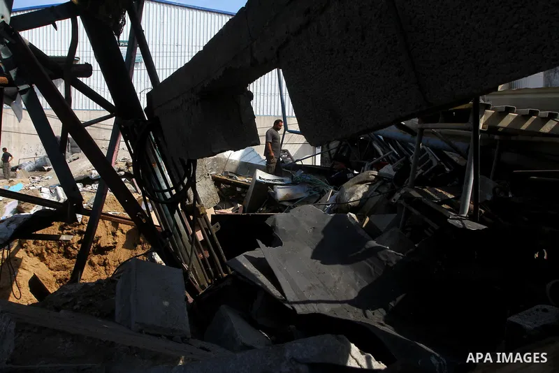 Palestinians inspect the site of an early morning Israeli airstrike in the al-Tuffah area, eastern Gaza City , which left one person wounded, on July 13, 2011, after Palestinians fired three rockets into southern Israel...