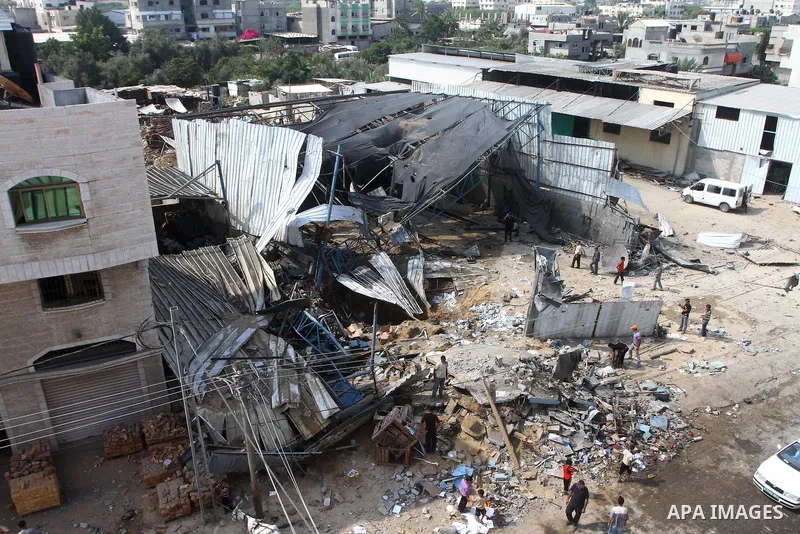 Palestinians inspect the site of an early morning Israeli airstrike in the al-Tuffah area, eastern Gaza City , which left one person wounded, on July 13, 2011, after Palestinians fired three rockets into southern Israel...