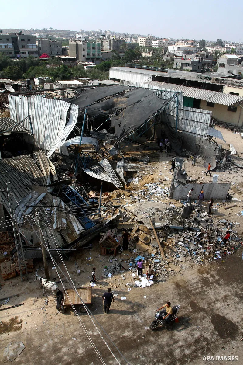 Palestinians inspect the site of an early morning Israeli airstrike in the al-Tuffah area, eastern Gaza City , which left one person wounded, on July 13, 2011, after Palestinians fired three rockets into southern Israel...