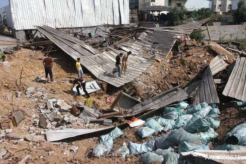 Palestinians inspect the site of an early morning Israeli airstrike in the al-Tuffah area, eastern Gaza City , which left one person wounded, on July 13, 2011, after Palestinians fired three rockets into southern Israel...