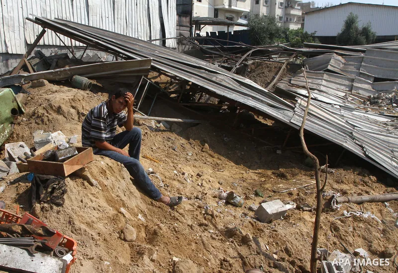 Palestinians inspect the site of an early morning Israeli airstrike in the al-Tuffah area, eastern Gaza City , which left one person wounded, on July 13, 2011, after Palestinians fired three rockets into southern Israel...
