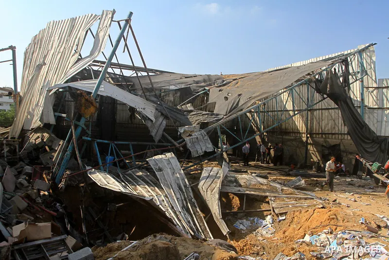 Palestinians inspect the site of an early morning Israeli airstrike in the al-Tuffah area, eastern Gaza City , which left one person wounded, on July 13, 2011, after Palestinians fired three rockets into southern Israel...
