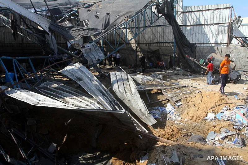 Palestinians inspect the site of an early morning Israeli airstrike in the al-Tuffah area, eastern Gaza City , which left one person wounded, on July 13, 2011, after Palestinians fired three rockets into southern Israel...