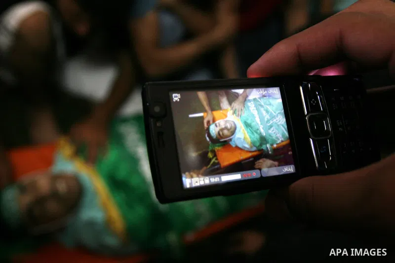 Palestinian mourners gather around the body of Ibrahim Sarhan, killed by Israeli military, during his funeral in the West Bank refugee camp of El Fara, north of Nablus, Wednesday, July 13, 2011. Sarhan was killed Wednesd...