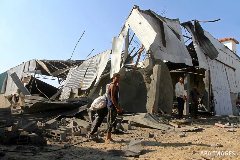 Palestinians inspect the rubble of a metal workshop after an Israeli air strike in Gaza city, early Thursday, July 14, 2011. Photo by Ashraf Amra